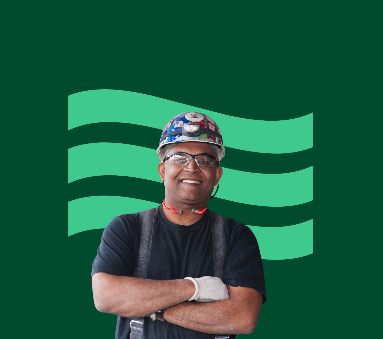 Man in a construction hard hat in front of a green flag.