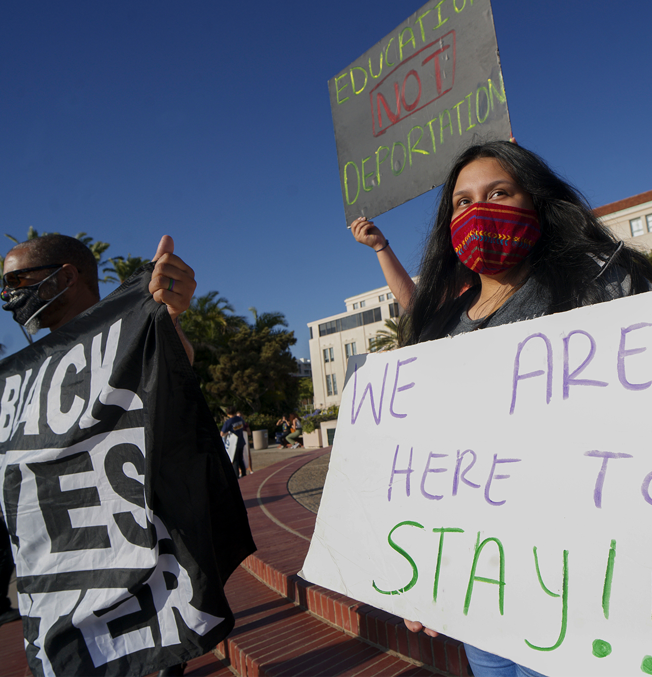 People hold signs during a rally in support of the Supreme Court's ruling in favor of the Deferred Action for Childhood Arrivals (DACA) program, in San Diego, California